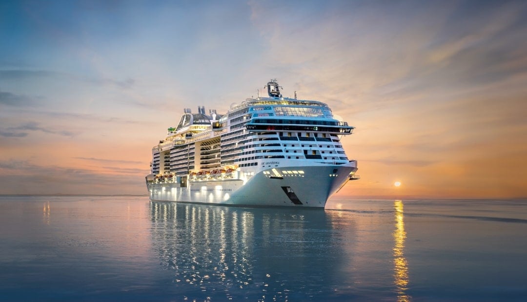 MSC Cruises MSC Grandiosa ship against a setting sun.